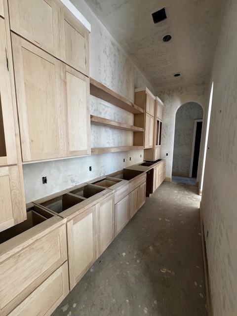 kitchen with concrete floors and light brown cabinets