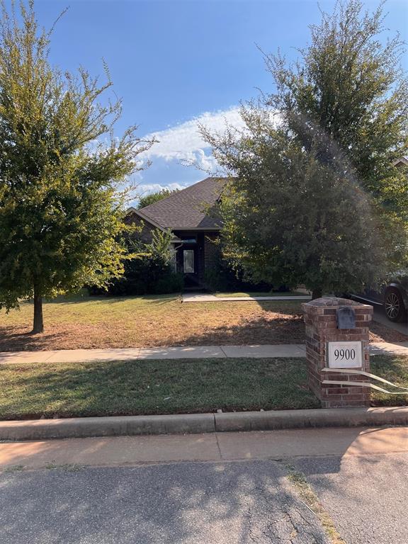 view of property hidden behind natural elements featuring a front yard