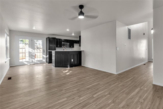 unfurnished living room featuring ceiling fan and light hardwood / wood-style floors