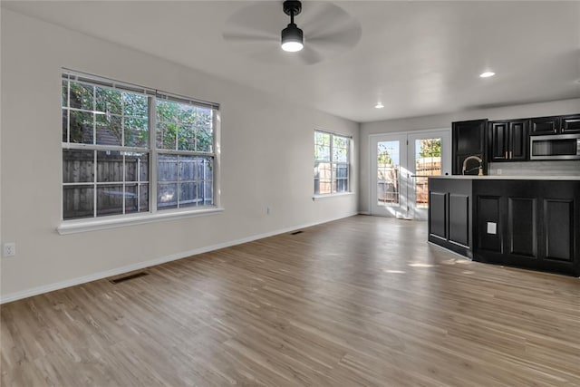 interior space with ceiling fan and light hardwood / wood-style flooring