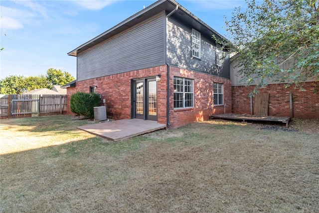 back of house featuring a patio, central air condition unit, and a lawn