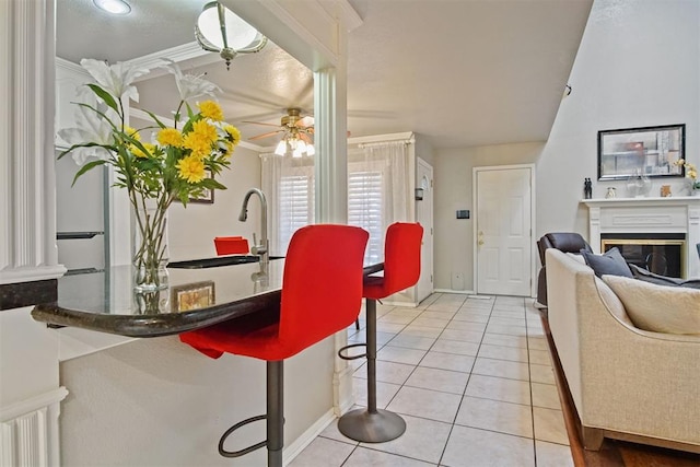 interior space featuring sink, light tile patterned flooring, ceiling fan, and crown molding