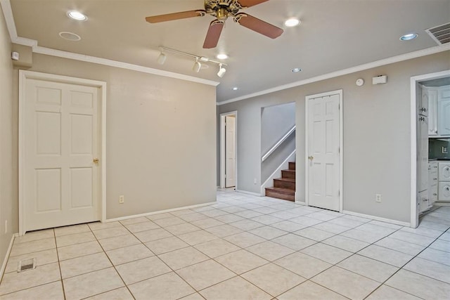 unfurnished room featuring track lighting, ceiling fan, light tile patterned floors, and ornamental molding