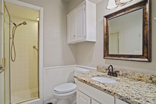 bathroom with toilet, a shower with door, and vanity