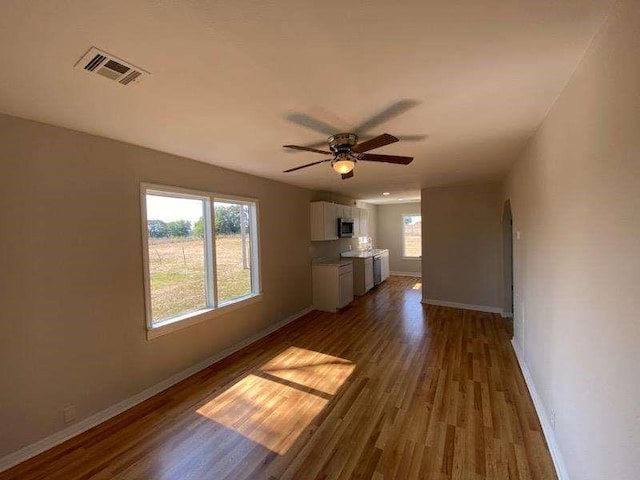 unfurnished living room featuring ceiling fan and dark wood-type flooring