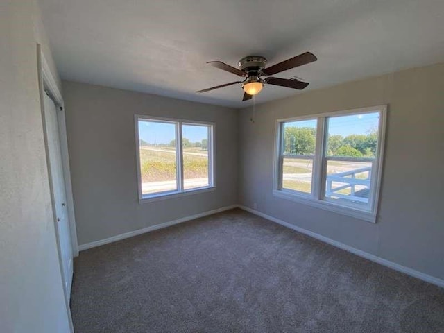 carpeted spare room featuring ceiling fan