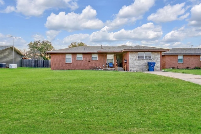 ranch-style house with central AC unit and a front yard