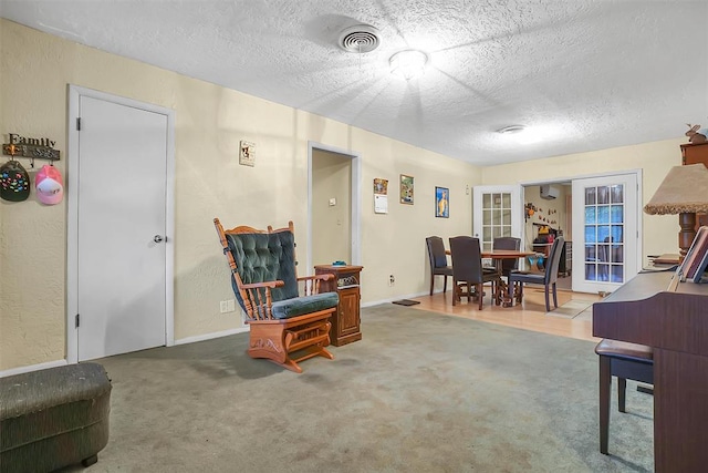 interior space featuring french doors, carpet, and a textured ceiling