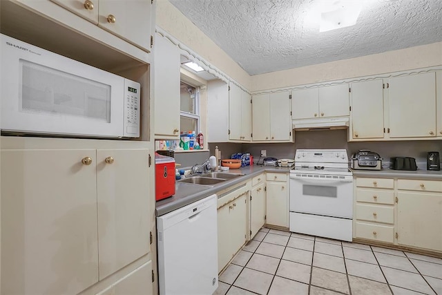 kitchen with a textured ceiling, sink, light tile patterned floors, and white appliances