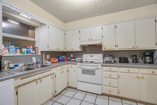 1304 N Market St, Cordell, OK 73632 - kitchen featuring white appliances, under cabinet range hood, light tile patterned flooring, light countertops, and a textured ceiling