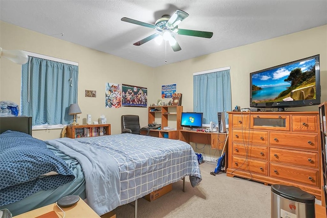 bedroom featuring a textured ceiling, carpet floors, and ceiling fan