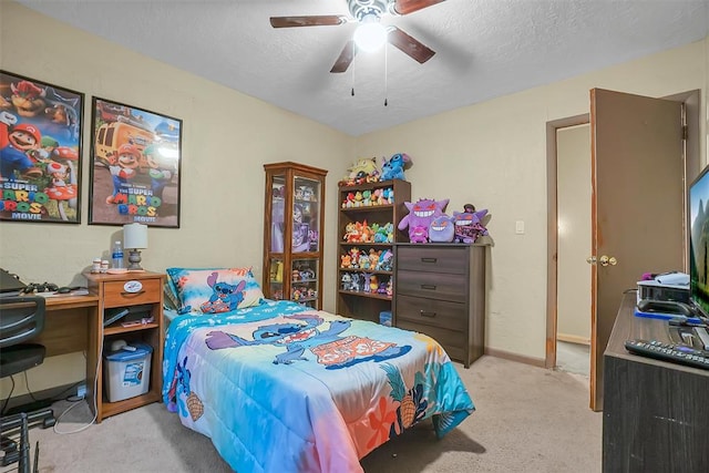 carpeted bedroom with ceiling fan and a textured ceiling