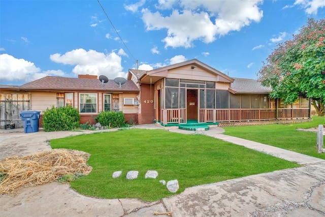 back of property with a yard and a sunroom