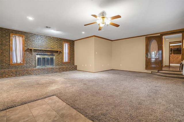 unfurnished living room with crown molding, a fireplace, carpet floors, and ceiling fan