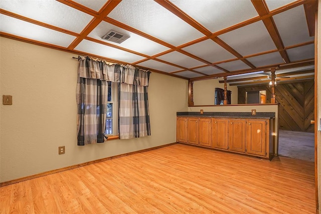 interior space featuring light wood-type flooring and coffered ceiling