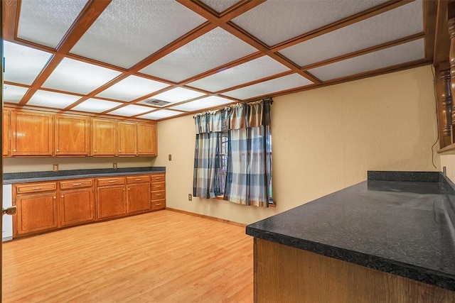 kitchen featuring a textured ceiling, light hardwood / wood-style flooring, and coffered ceiling