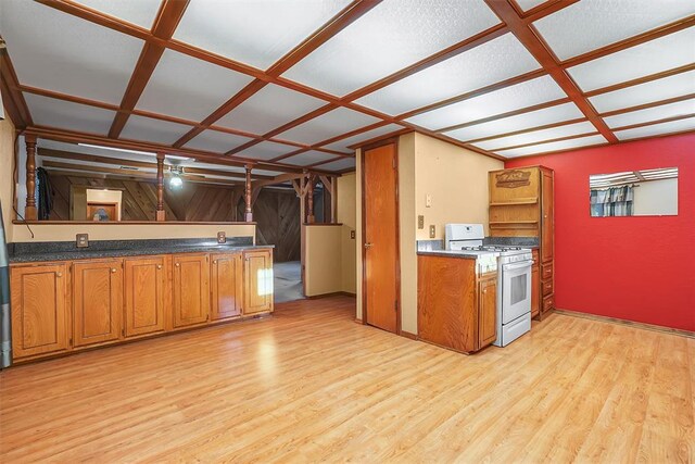 kitchen with white range with gas stovetop, light hardwood / wood-style flooring, and coffered ceiling