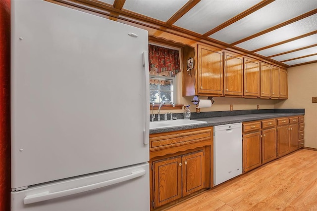 kitchen with light wood-type flooring, white appliances, and sink