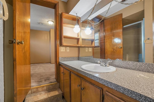 bathroom with a textured ceiling, vanity, and tile patterned floors