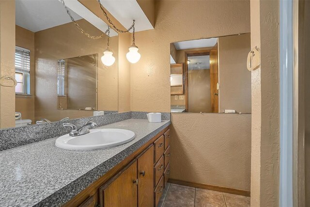 420 W 8th St, Cordell, OK 73632 - bathroom featuring a textured wall, vanity, tile patterned floors, and toilet