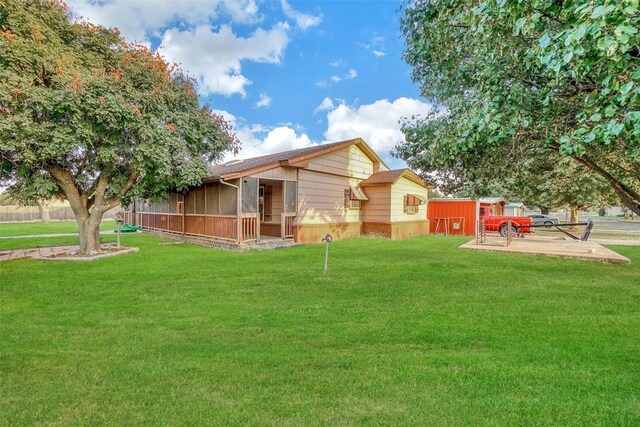 420 W 8th St, Cordell, OK 73632 - rear view of house with a sunroom and a lawn