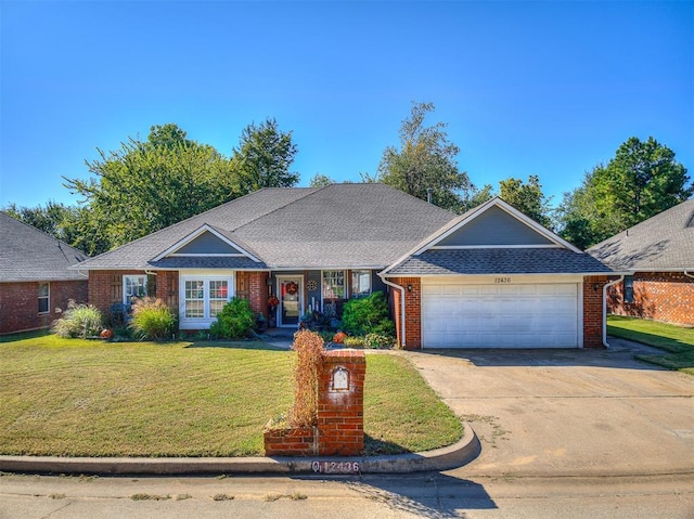 ranch-style house featuring a front yard and a garage