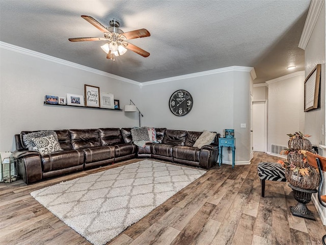 living room featuring crown molding, hardwood / wood-style floors, ceiling fan, and a textured ceiling