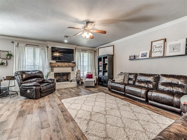 living room featuring a wealth of natural light, crown molding, wood-type flooring, and a textured ceiling