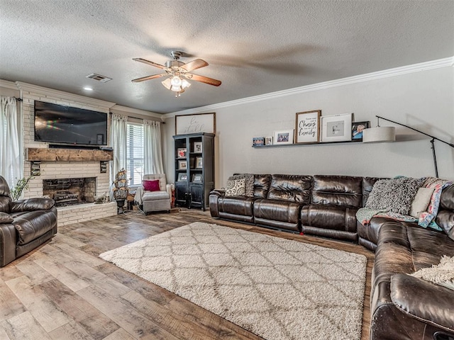 living room with ceiling fan, hardwood / wood-style floors, a textured ceiling, and ornamental molding