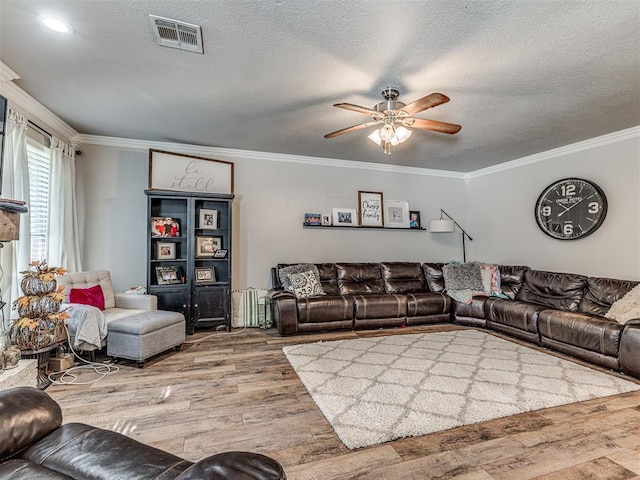 living room with hardwood / wood-style flooring, ceiling fan, and crown molding