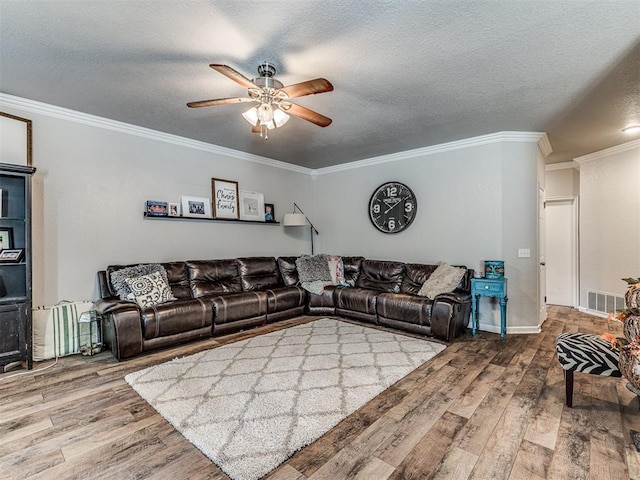 living room featuring hardwood / wood-style flooring, ceiling fan, crown molding, and a textured ceiling