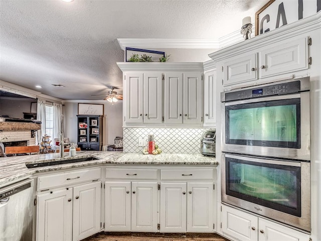 kitchen featuring stainless steel appliances, white cabinetry, and crown molding