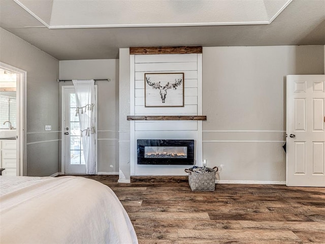 bedroom featuring a textured ceiling, a large fireplace, sink, and dark wood-type flooring