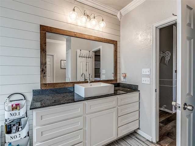 bathroom with wood walls, vanity, ornamental molding, and hardwood / wood-style flooring