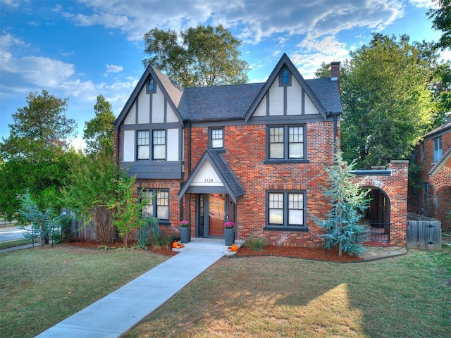 tudor-style house featuring a front lawn