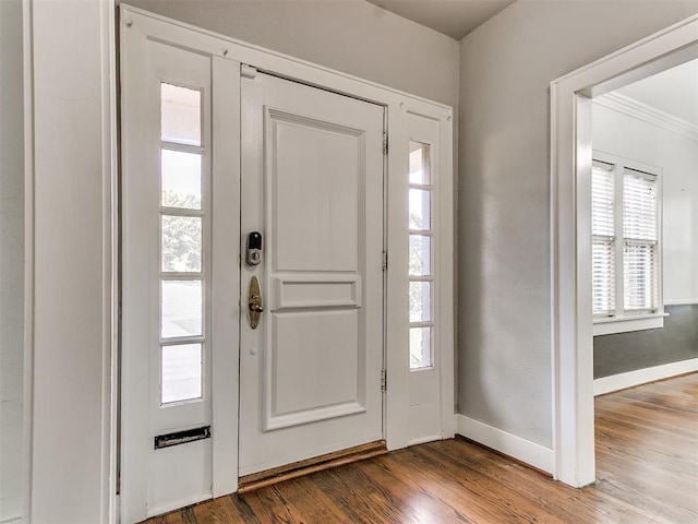 entryway with hardwood / wood-style flooring and crown molding