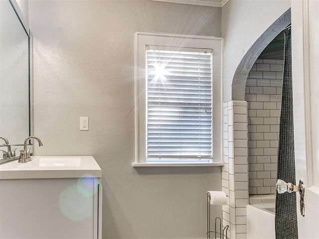 bathroom featuring tiled shower / bath, vanity, and a wealth of natural light