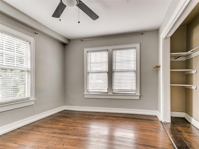 unfurnished room featuring ceiling fan and dark wood-type flooring