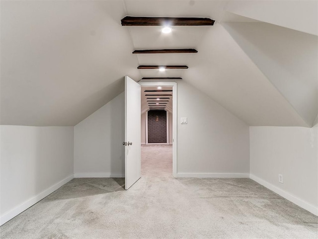 bonus room featuring vaulted ceiling with beams and light carpet