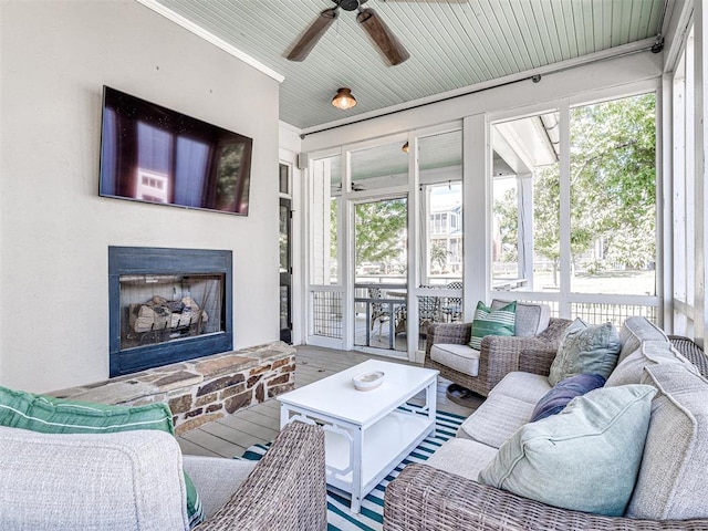 living room featuring a fireplace, wood-type flooring, crown molding, and a healthy amount of sunlight