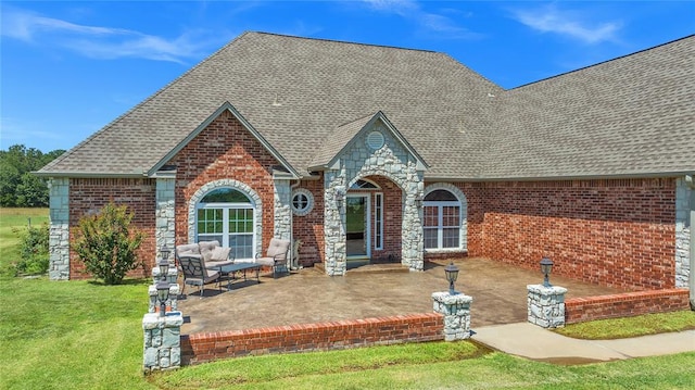 tudor home featuring a front lawn and a patio area