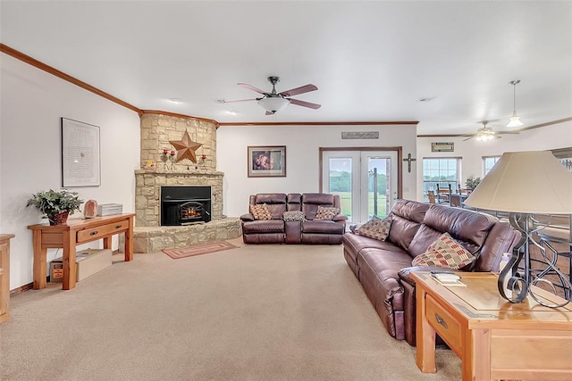 carpeted living room featuring a fireplace, french doors, ceiling fan, and crown molding