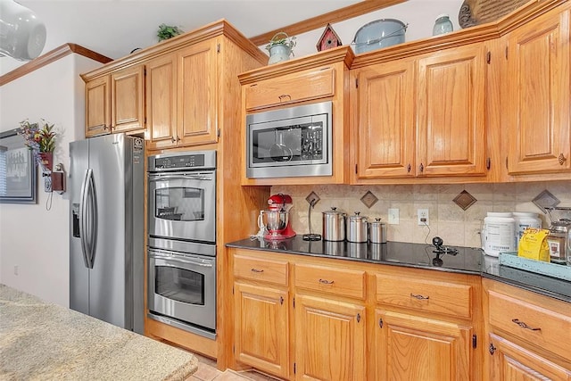 kitchen featuring decorative backsplash, stainless steel appliances, and light tile patterned flooring