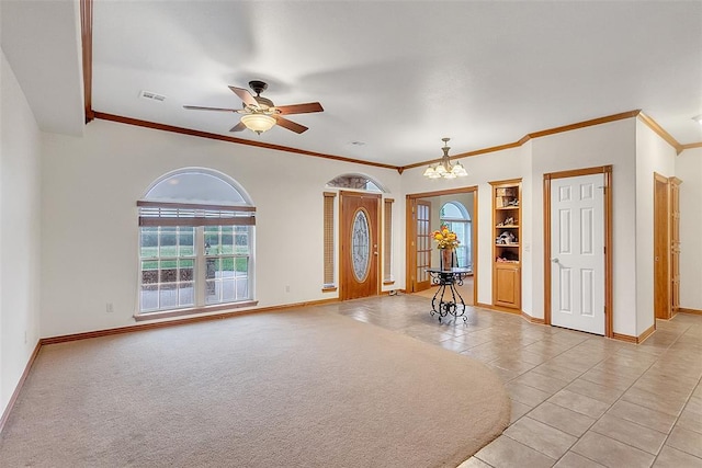 tiled entrance foyer with ceiling fan with notable chandelier, crown molding, and a healthy amount of sunlight