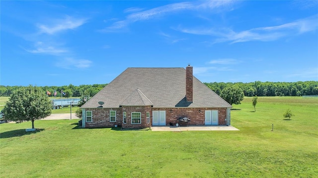 rear view of property with a yard and a patio