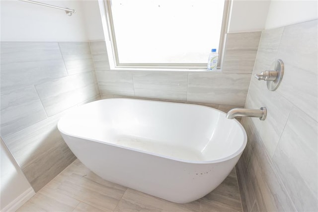 full bath featuring tile walls and a soaking tub