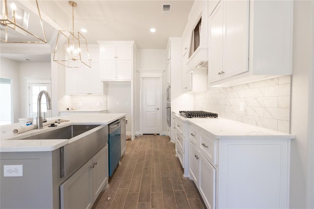 kitchen featuring visible vents, a sink, dark wood-type flooring, white cabinets, and appliances with stainless steel finishes