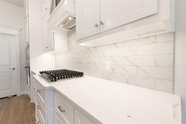 kitchen with custom exhaust hood, white cabinets, appliances with stainless steel finishes, and backsplash