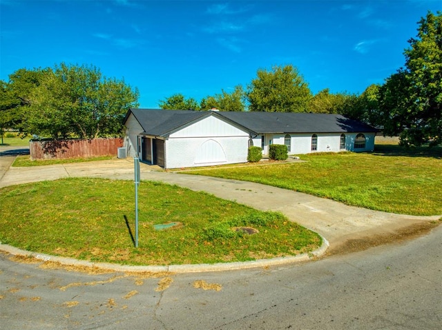 ranch-style home with a garage and a front lawn