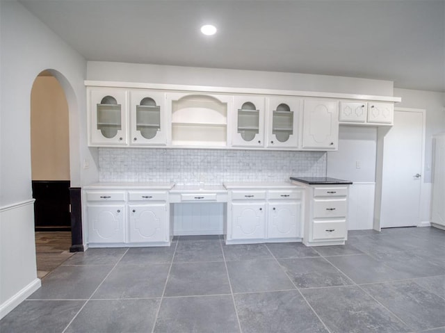 kitchen with white cabinetry, decorative backsplash, and dark tile patterned floors